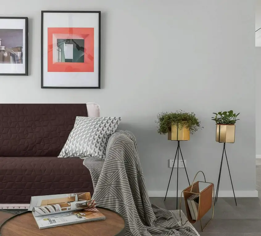 Chocolate quilted Ameritex sofa cover with a grey throw in a bright living room