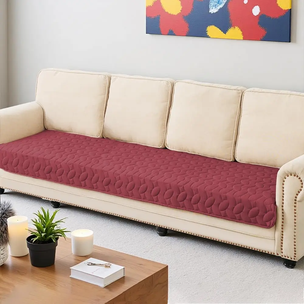 Burgundy quilted Ameritex cover laid along the seats of a cream three-seat sofa